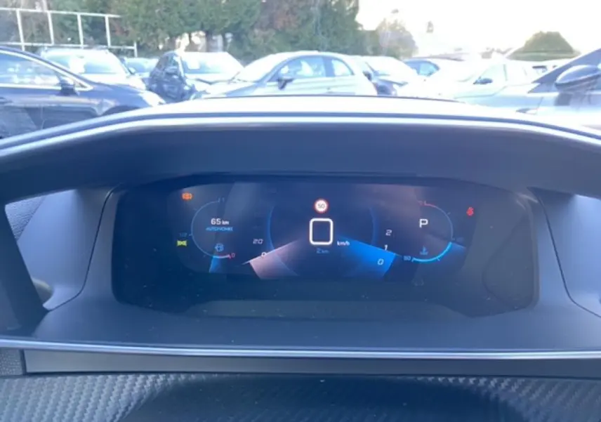 Vue rapprochée du combiné numérique 3D du tableau de bord du Peugeot 2008 noir, affichant la vitesse et l'autonomie.