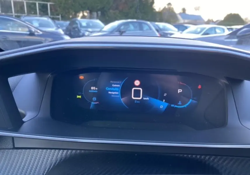 Vue rapprochée du combiné numérique 3D du Peugeot 2008 noir 2021, affichant la vitesse et les aides à la conduite.