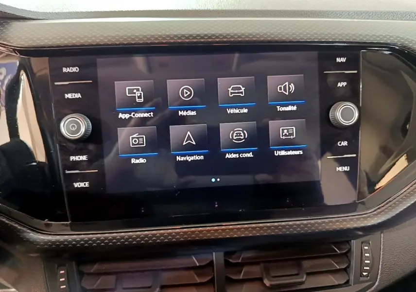 Écran tactile central du Volkswagen T-Cross gris foncé, affichant le menu multimédia et navigation.
