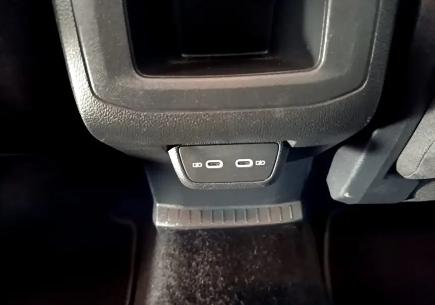 Vue rapprochée des prises USB arrière du Volkswagen T-Cross gris foncé, version 2023, à l'intérieur du véhicule.