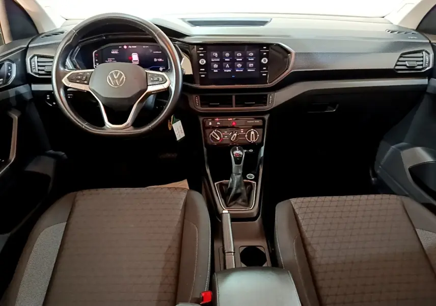 Vue intérieure avant du Volkswagen T-Cross 2023, volant cuir multifonctions et tableau de bord avec écran tactile central.