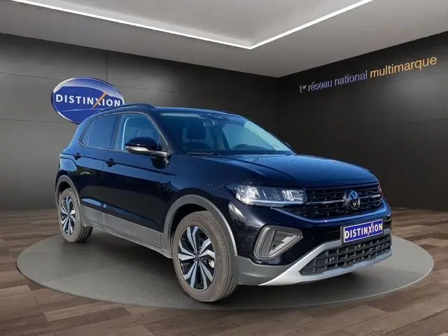 Volkswagen T-Cross noir en 3/4 avant droit, avec jantes alliage et calandre marquée, en showroom Distinxion.