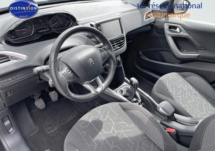 Intérieur du Peugeot 2008 noir métal 2016, vue côté conducteur montrant tableau de bord, volant et sièges tissu gris noir.