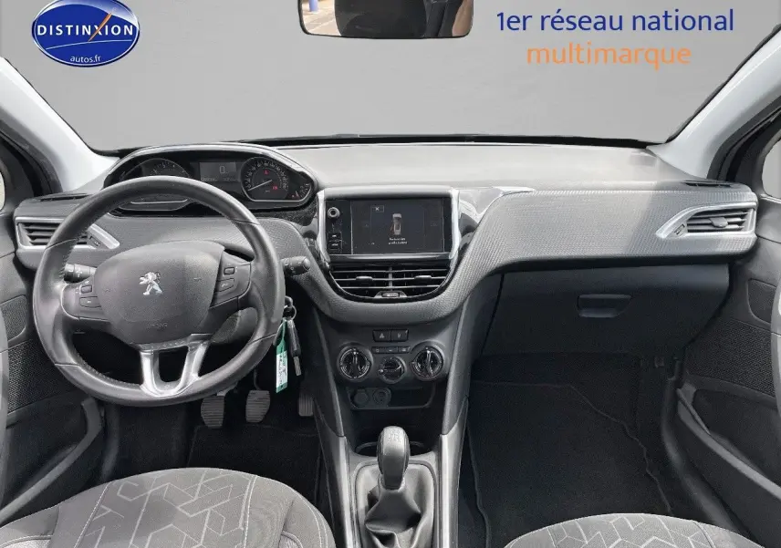 Vue intérieure avant du Peugeot 2008 noir métal de 2016, montrant le volant, la console centrale et les sièges gris.