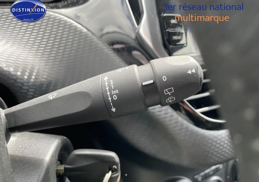 Gros plan sur la commande d'essuie-glace à gauche du volant d'une Peugeot 2008 noire métal de 2016.