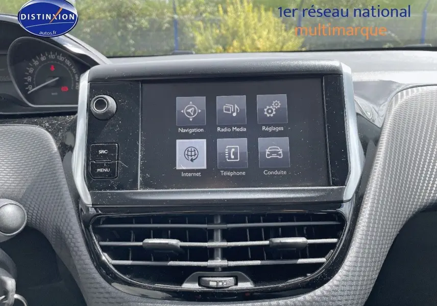 Vue rapprochée de l’écran tactile central et des aérateurs du tableau de bord gris du Peugeot 2008 noir métal de 2016.