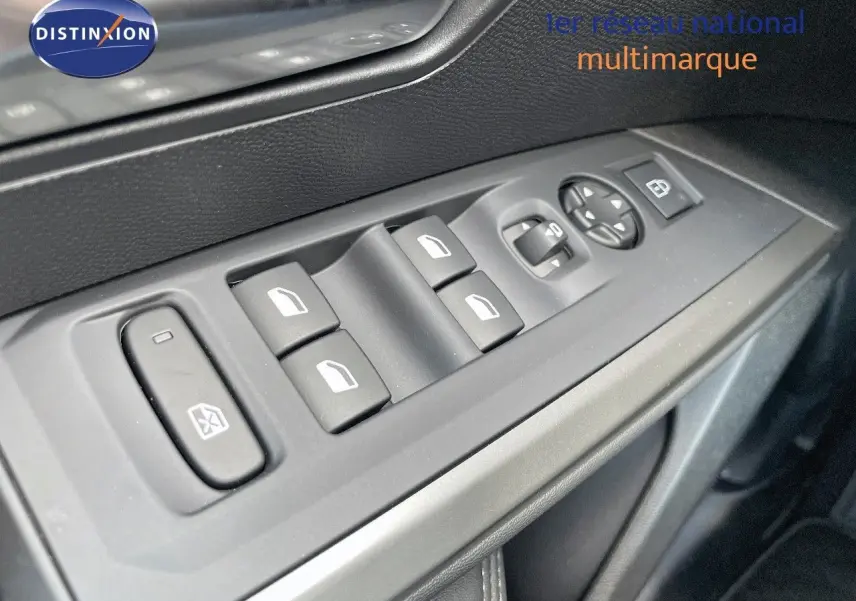 Gros plan sur les commandes de lève-vitres et rétroviseurs côté gauche d'un Peugeot 3008 bleu Ingaro Metal 2025.