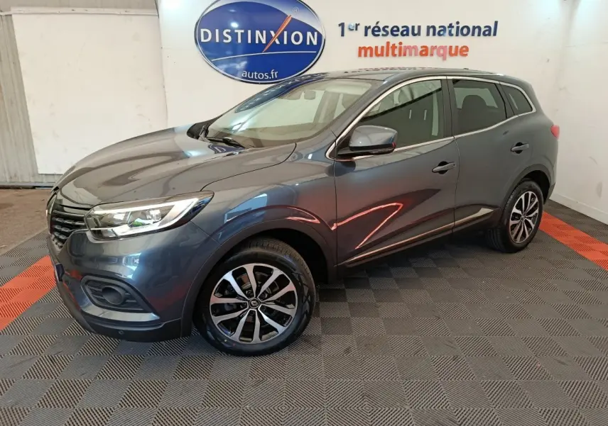 Renault Kadjar Business gris foncé vu en 3/4 avant droit avec jantes alliage et feux LED dans un showroom.