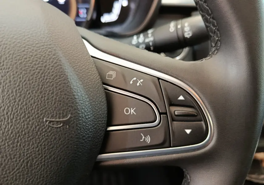 Gros plan sur les commandes multifonctions du volant noir du Renault Kadjar Business 2022, boutons de navigation et appel.
