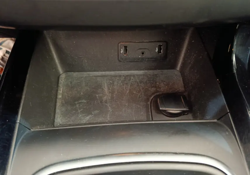 Prise USB double et prise 12V noire dans l'espace de rangement central d'un Renault Kadjar gris foncé 2022.