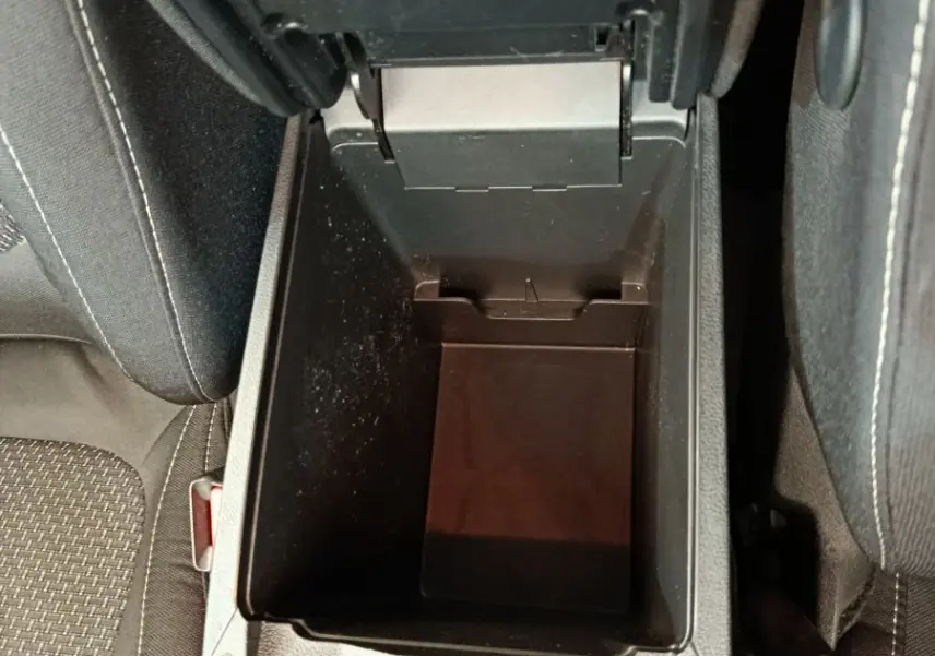 Vue plongeante sur le rangement central ouvert entre les sièges avant du Renault Kadjar Business gris foncé de 2022.