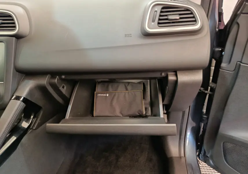 Gros plan sur la boîte à gants ouverte du Renault Kadjar gris foncé Business Blue dCi 115 EDC 2022 avec pochette Renault visible.