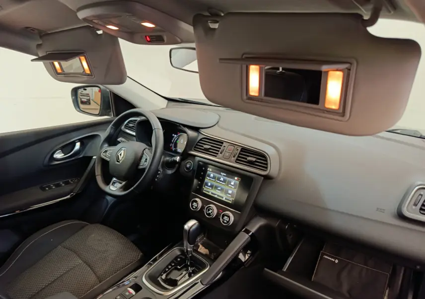 Intérieur du Renault Kadjar Business 2022 vu côté conducteur, tableau de bord gris avec écran tactile allumé.