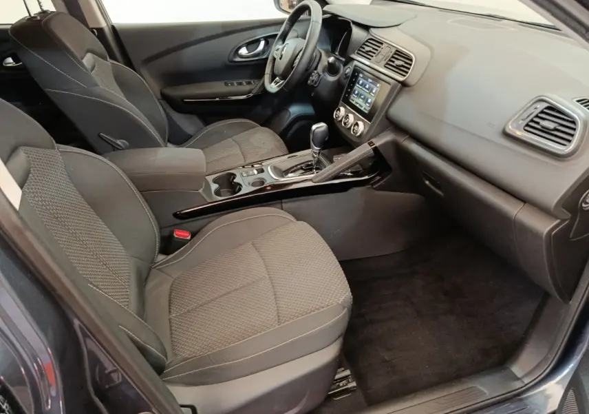 Intérieur avant droit du Renault Kadjar Business gris foncé, montrant sièges tissu et console centrale avec écran tactile.
