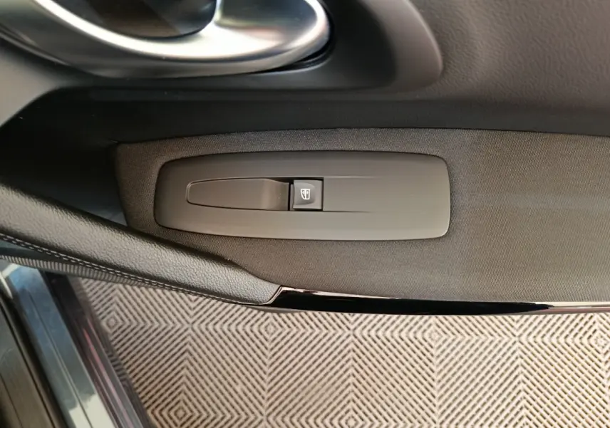 Détail de la commande de lève-vitre sur la porte côté conducteur du Renault Kadjar gris foncé 2022.