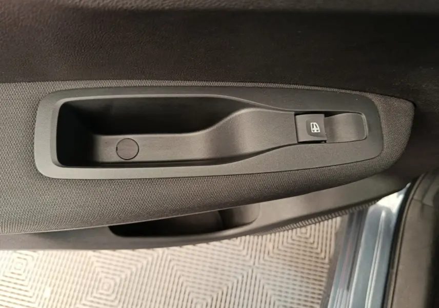 Poignée intérieure noire avec bouton de lève-vitre sur la porte côté conducteur du Renault Kadjar gris foncé 2022.