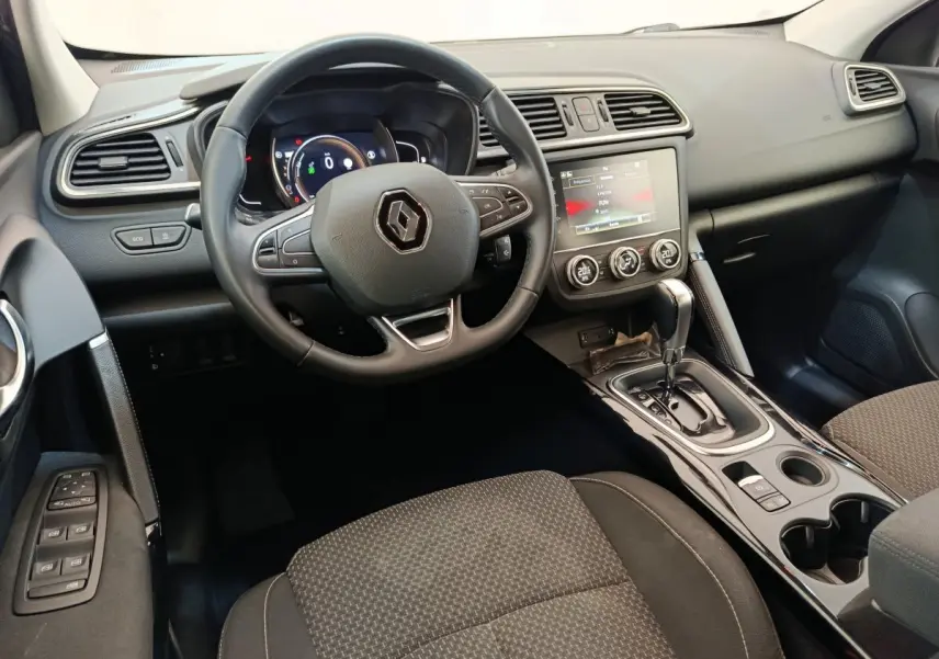 Vue intérieure avant du Renault Kadjar Business gris foncé, tableau de bord avec écran tactile et volant multifonctions.