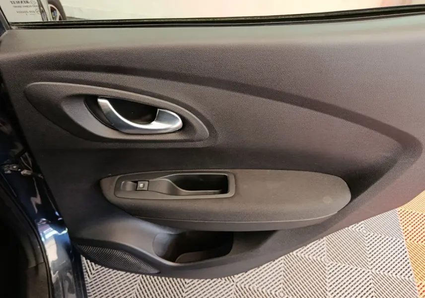 Gros plan sur la porte intérieure côté gauche du Renault Kadjar gris foncé, avec poignée et commande de vitre.