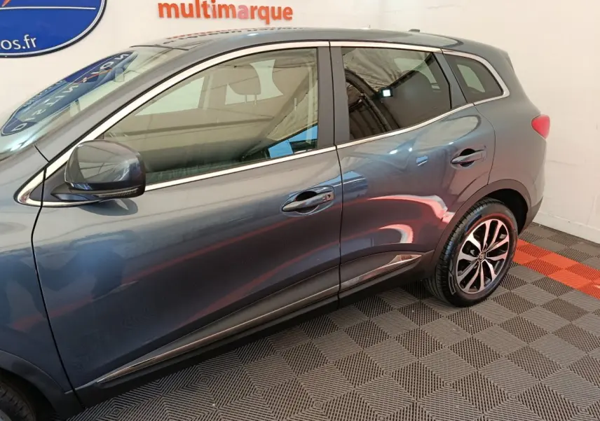 Profil côté gauche du Renault Kadjar gris foncé 2022 avec jantes alliage et rétroviseur électrique.