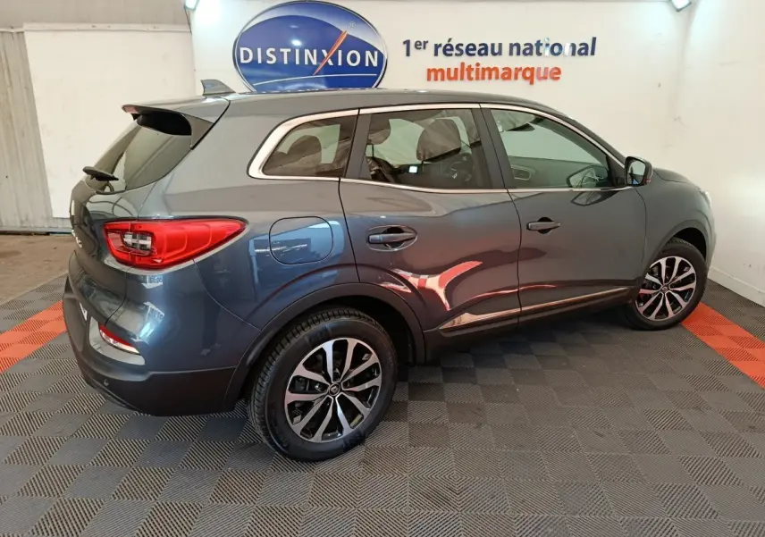 Renault Kadjar Business gris foncé vu de profil droit en intérieur avec jantes alliage et logo Distinxion en arrière-plan.