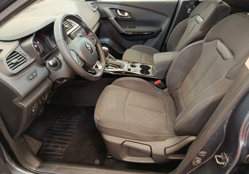 Intérieur avant droit du Renault Kadjar Business gris foncé 2022, sièges tissu et tableau de bord moderne avec volant multifonctions.