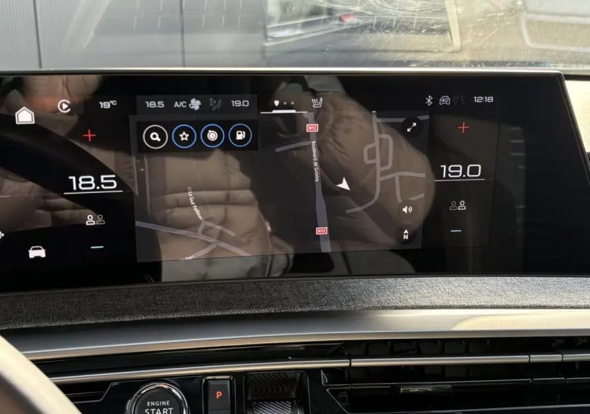 Écran tactile panoramique du tableau de bord du Peugeot 3008 Hybrid blanc, affichant la navigation GPS.