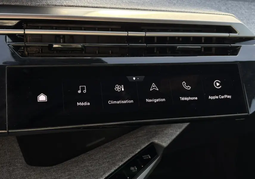 Vue rapprochée de l’écran tactile central noir du Peugeot 3008 Hybrid 2025 avec commandes multimédia et climatisation.
