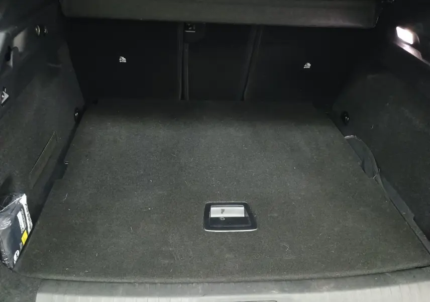 Vue intérieure du coffre du Peugeot 3008 Hybrid 145 Allure, plancher modulable et revêtement noir.