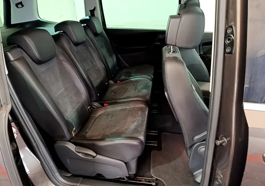 Vue intérieure côté gauche montrant les sièges arrière individuels en cuir et alcantara du Volkswagen Sharan marron.