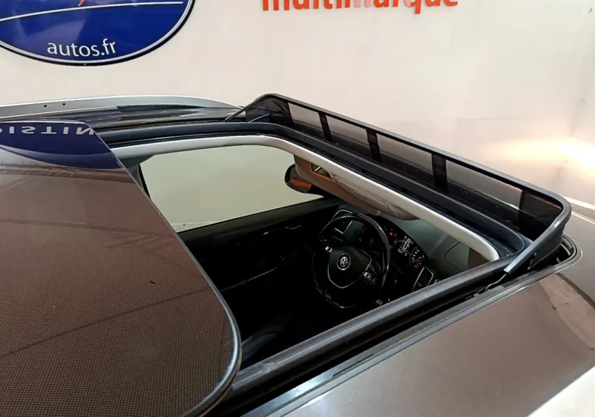 Vue plongeante sur le toit ouvrant panoramique d’un Volkswagen Sharan marron, avec intérieur noir visible.