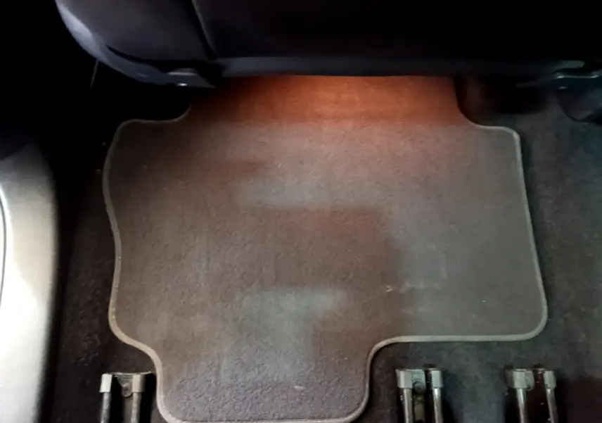 Vue rapprochée du tapis de sol arrière marron du Volkswagen Sharan 2017, avec éclairage intérieur chaud.