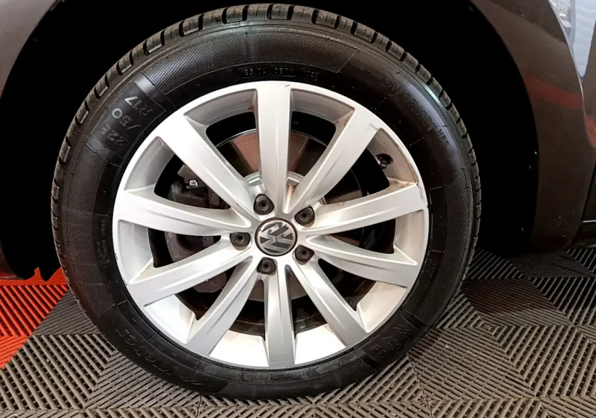 Gros plan sur la roue avant droite avec jante alliage argentée du Volkswagen Sharan marron 2017.