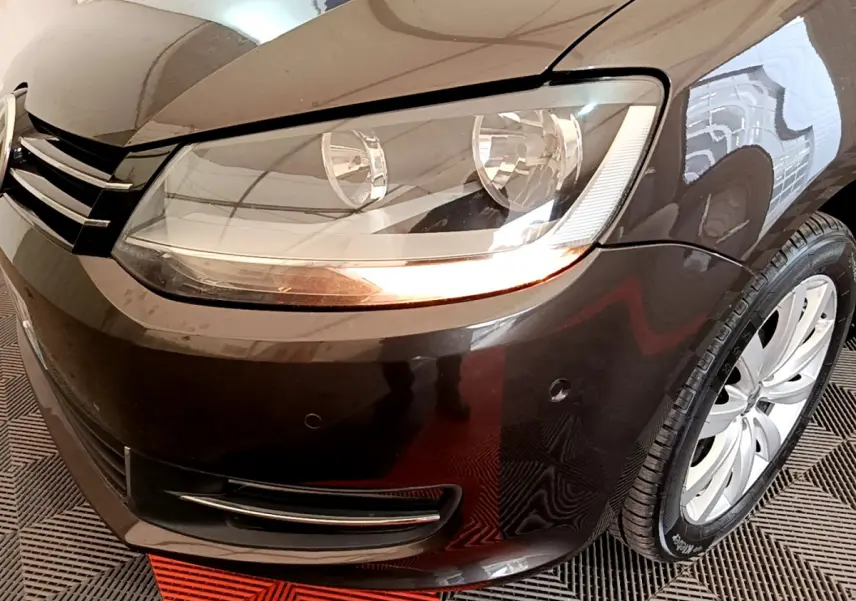 Gros plan sur l'avant droit marron du Volkswagen Sharan 2017, mettant en valeur le phare et la roue.