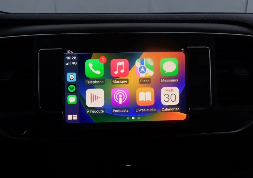 Écran tactile multimédia allumé dans l'habitacle du Peugeot Expert Fourgon noir, affichant les applications connectées.