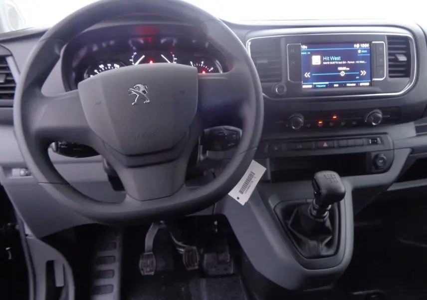 Intérieur du Peugeot Expert Fourgon noir 2022, vue du tableau de bord avec volant, levier de vitesse manuel et écran tactile.