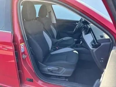 Vue intérieure côté conducteur de la Skoda Scala rouge velvet metal 2024, mettant en valeur les sièges et le tableau de bord moderne.