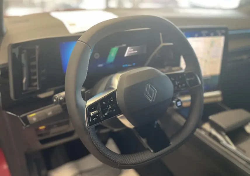 Gros plan sur le volant textile refined noir du Renault Rafale 2025 avec tableau de bord numérique et écran tactile multimédia.