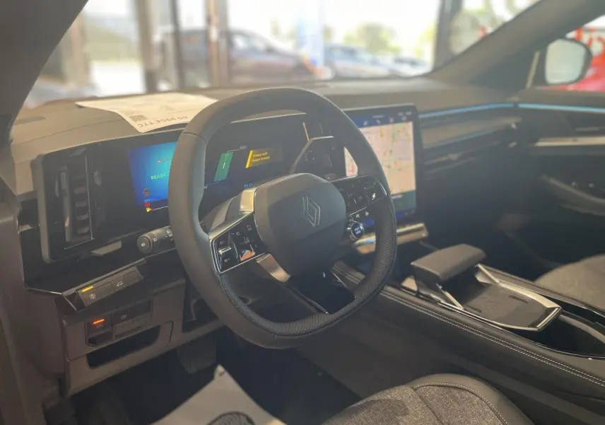 Intérieur du Renault Rafale 2025 vu côté conducteur, volant multifonction et écran tactile central lumineux.