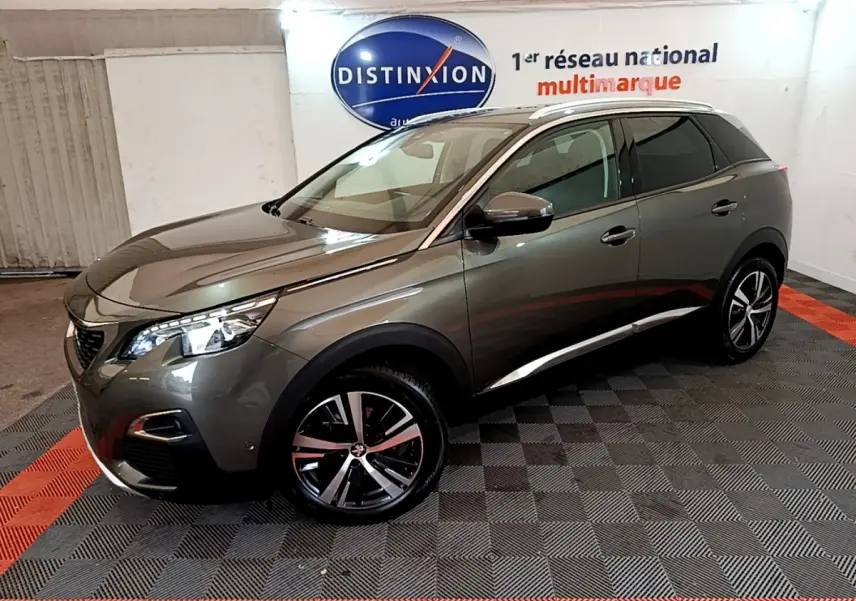 Peugeot 3008 gris clair en 3/4 avant droit, avec jantes alliage et toit panoramique en intérieur showroom.