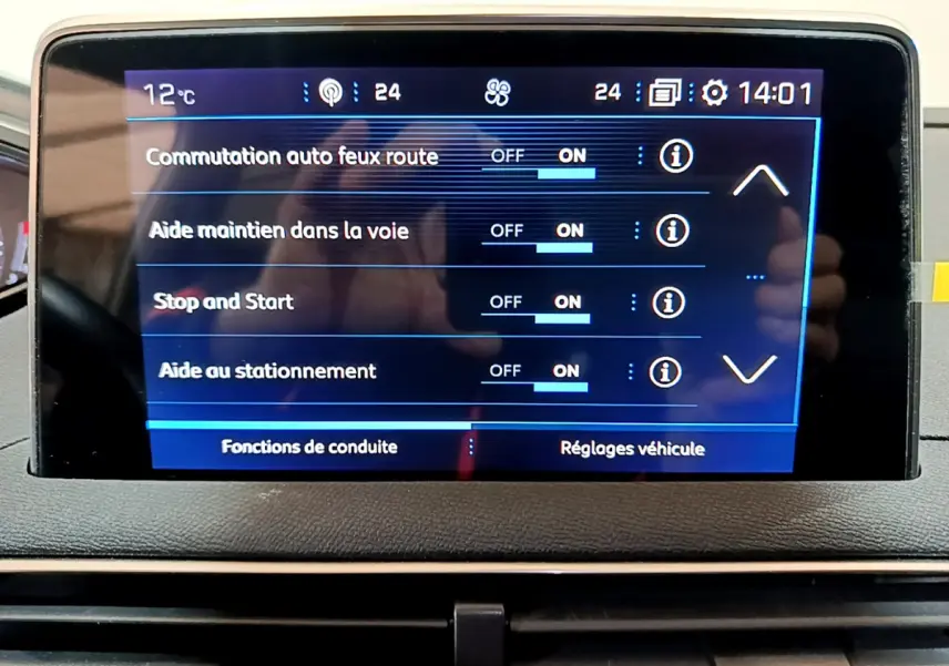 Écran tactile central du tableau de bord du Peugeot 3008 gris clair, affichant les aides à la conduite activées.