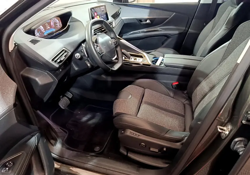Intérieur avant droit du Peugeot 3008 gris clair 2020, avec tableau de bord digital et sièges tissu-cuir bicolores.