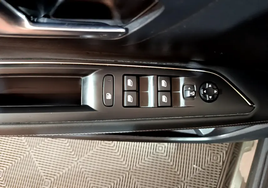 Panneau de commande des vitres et rétroviseurs côté gauche en cuir noir dans un Peugeot 3008 gris clair 2020.