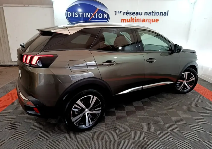 Vue 3/4 arrière droite d'un Peugeot 3008 gris clair avec feux arrière LED et jantes alliage noires et argentées.