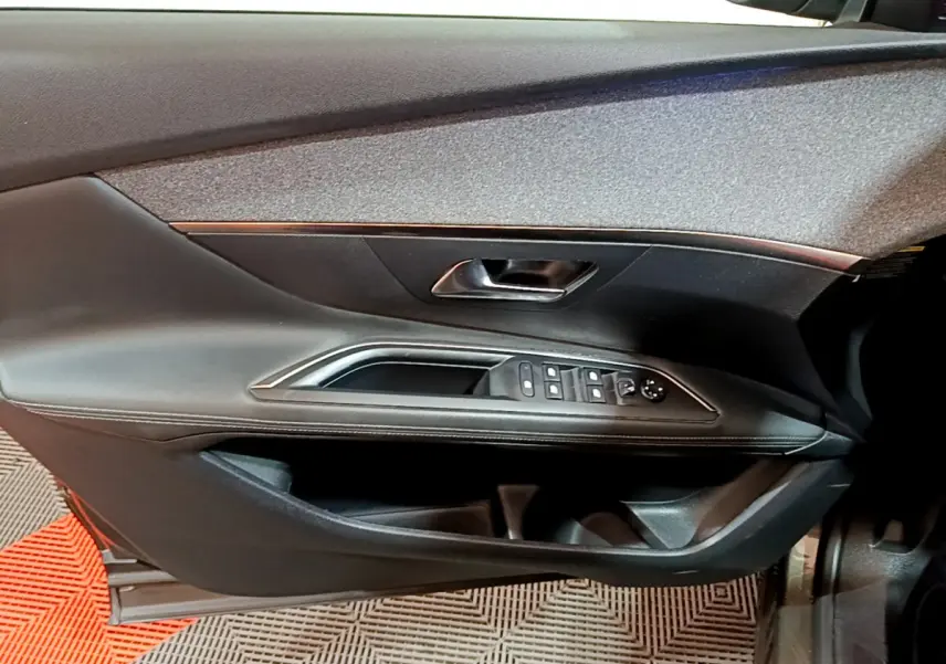 Vue rapprochée de la porte côté gauche du Peugeot 3008 gris clair, avec commandes de vitres et poignée intégrée.