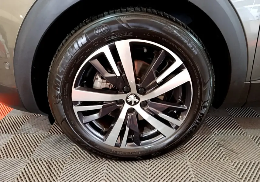Gros plan sur la roue avant droite gris clair du Peugeot 3008 avec jante alliage et pneu Michelin visible.