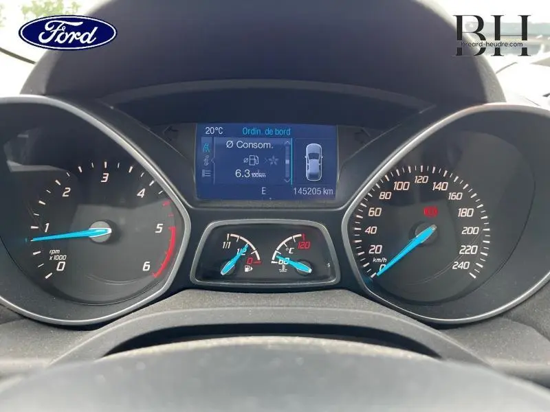 Tableau de bord du Ford Kuga 2015 affichant consommation, vitesse et compte-tours avec écran multifonction bleu.