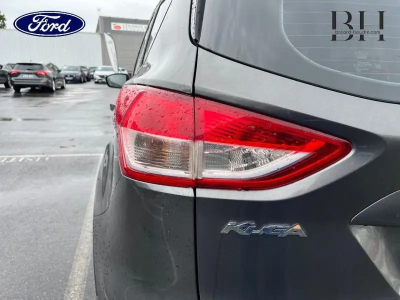 Gros plan sur le feu arrière droit d'un Ford Kuga gris Magnetic avec logo Kuga visible sur le hayon.