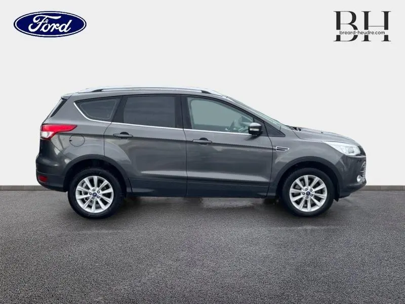 Profil droit d'un Ford Kuga gris Magnetic de 2015 avec jantes alliage et vitres teintées sur fond neutre.