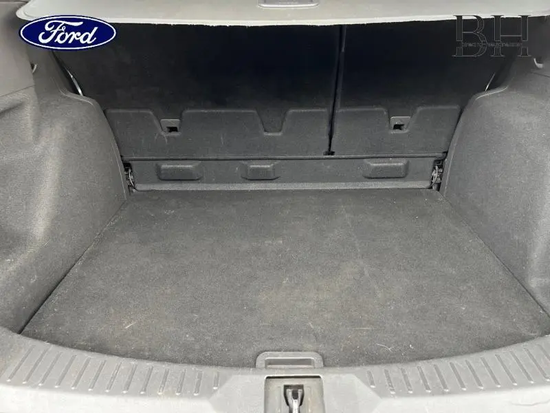 Coffre vide en vue intérieure arrière d'un Ford Kuga gris Magnetic, soulignant son espace de chargement.