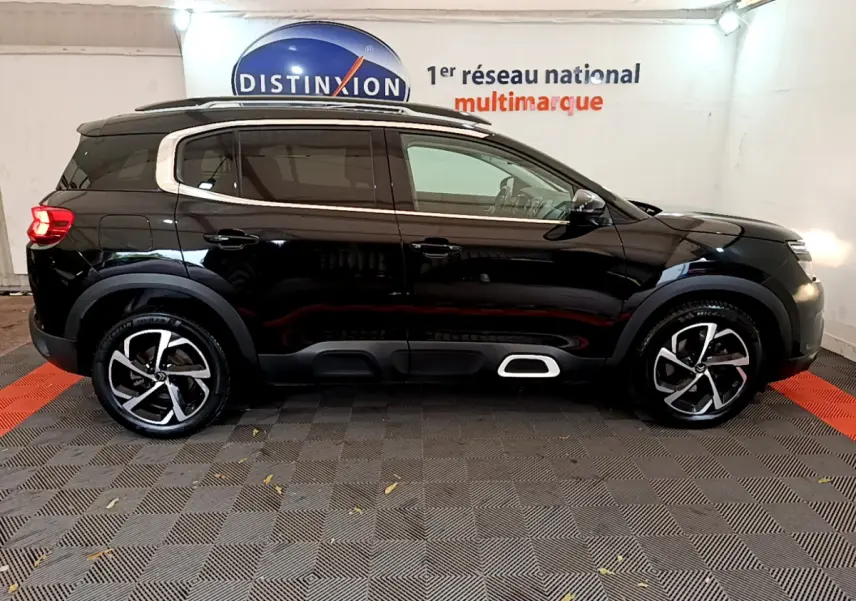 Profil droit d'un Citroën C5 Aircross noir 2020 avec jantes alliage et protections latérales blanches.